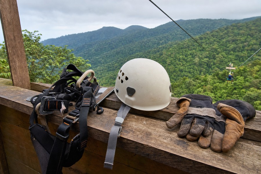 Zipline harness and helmet gear laid out at a check-in platform before a Kauai zipline tour